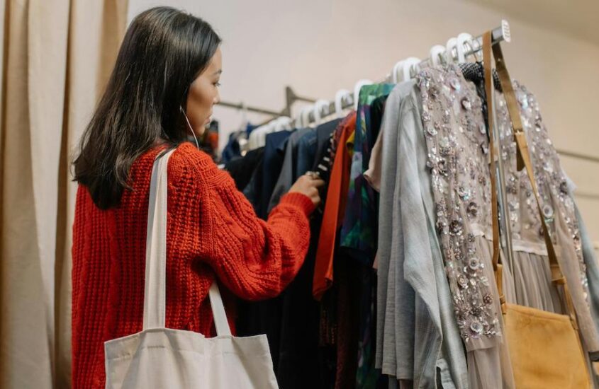 A woman shopping for clothes in a thrift store.