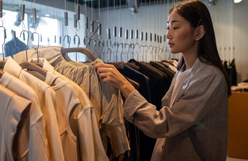 Woman browsing clothing rack.